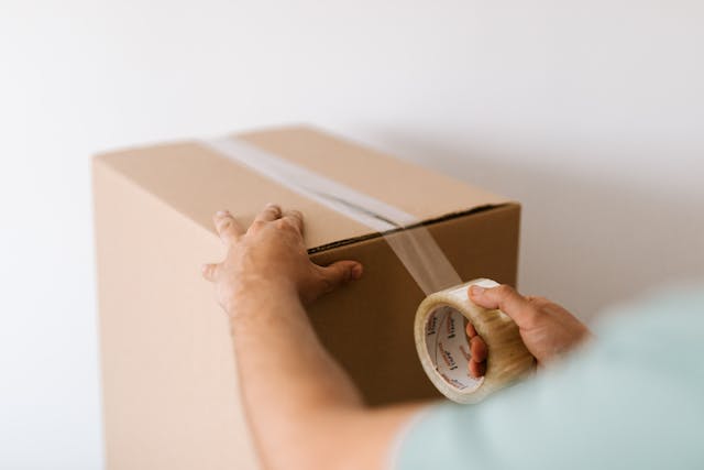 Person taping a box shut